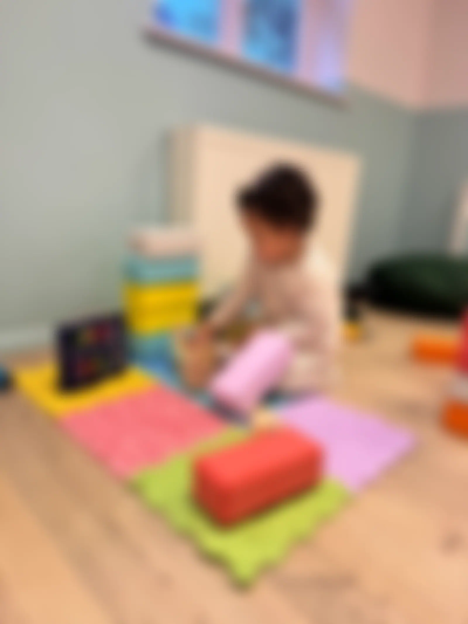 Child building with soft foam blocks on textured sensory mats