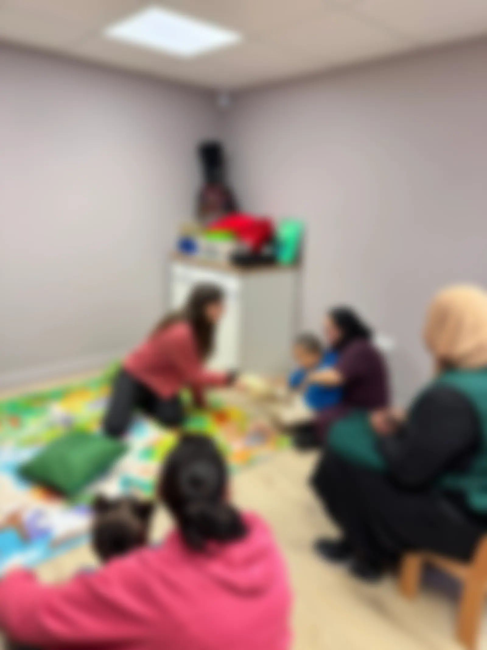 Parents and practitioners on the floor during a Stay and Play session